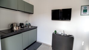 Una cocina moderna con estufa integrada, lavaplatos y un refrigerador pequeño.