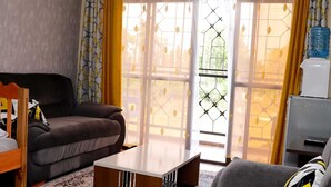 Una sala de estar con un sofá, una mesa de centro y un mueble para televisión.