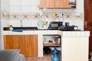 Familie appartement, uitzicht op stad | Privékeuken | Een koelkast, een magnetron, kookgerei, borden en bestek