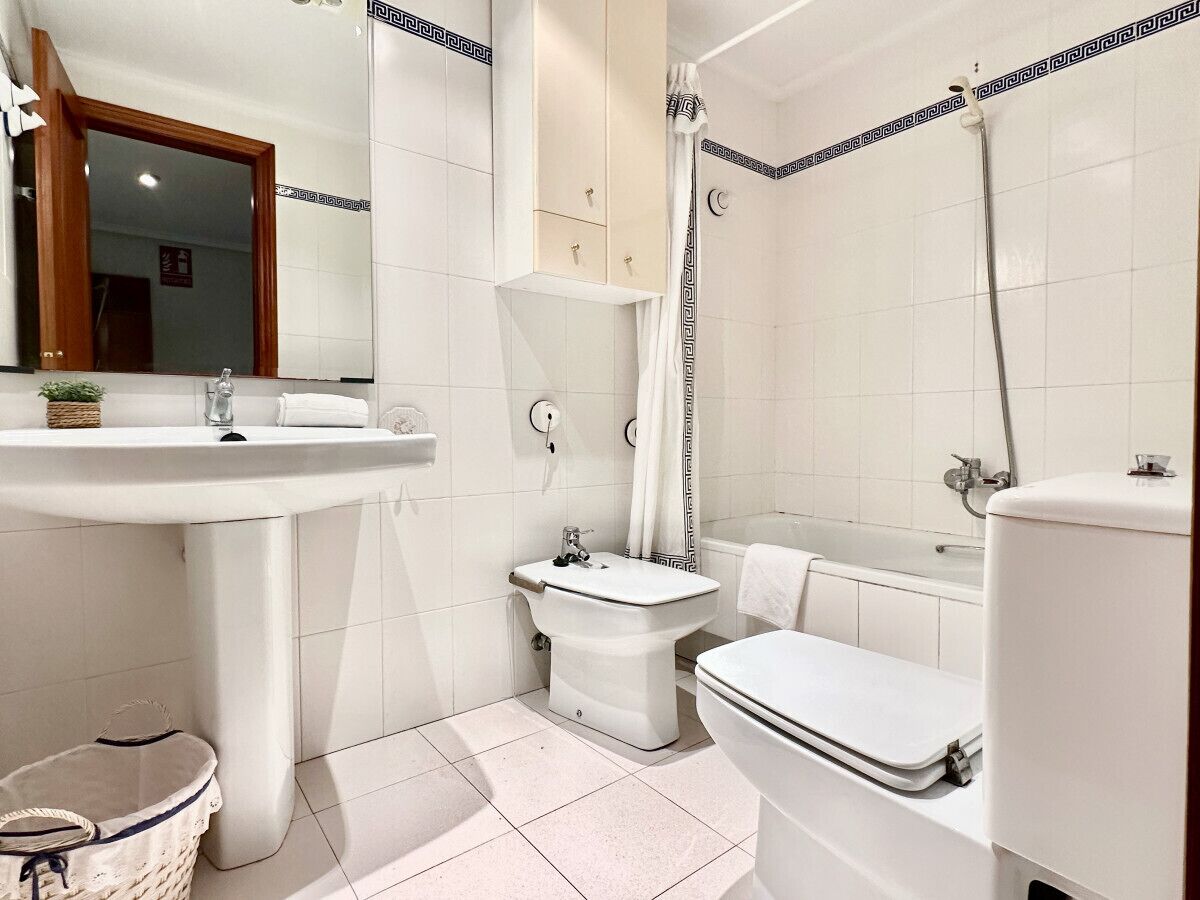 Une salle de bain avec un lavabo, des toilettes et une douche.