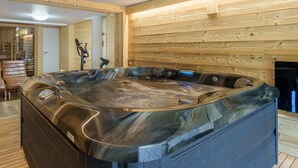 A modern spa room with a large hot tub, wooden walls, and a wooden floor. - Gorgeous home in Gérardmer with sauna (Gérardmer)