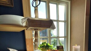 A breakfast buffet with bread, rolls, and a candle on a wooden counter by a window. - älgbergets b&b (Ucklum)
