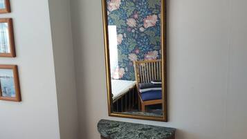 A mirror with a floral pattern, mounted on a wall above a marble console table.