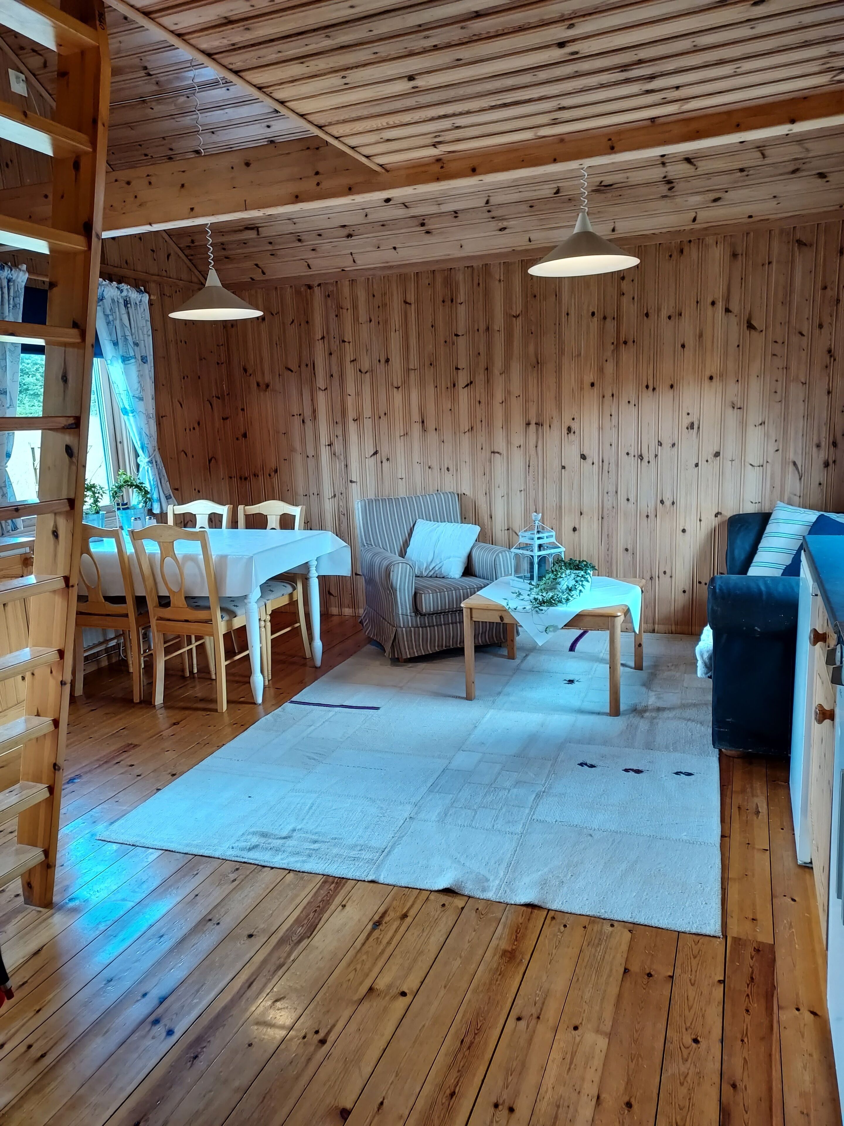 Un interior de madera con un comedor, un sofá y un sofá azul.