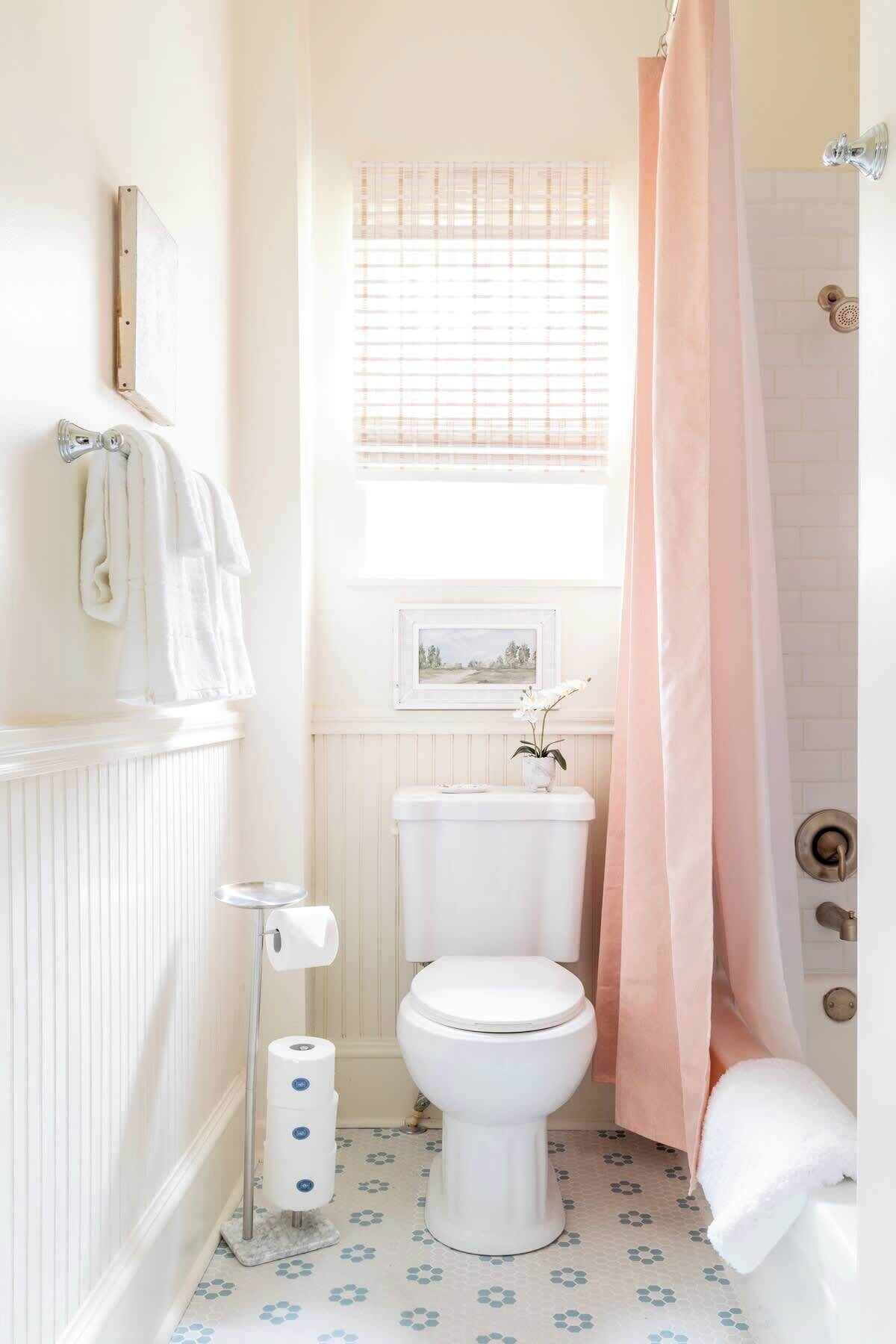 A small bathroom with a toilet, a bidet, a shower curtain, and a radiator.