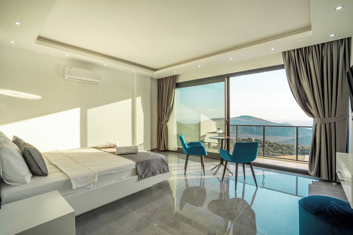 Une chambre d’hôtel moderne dotée d’un grand lit, d’un balcon avec vue et d’un coin repas.