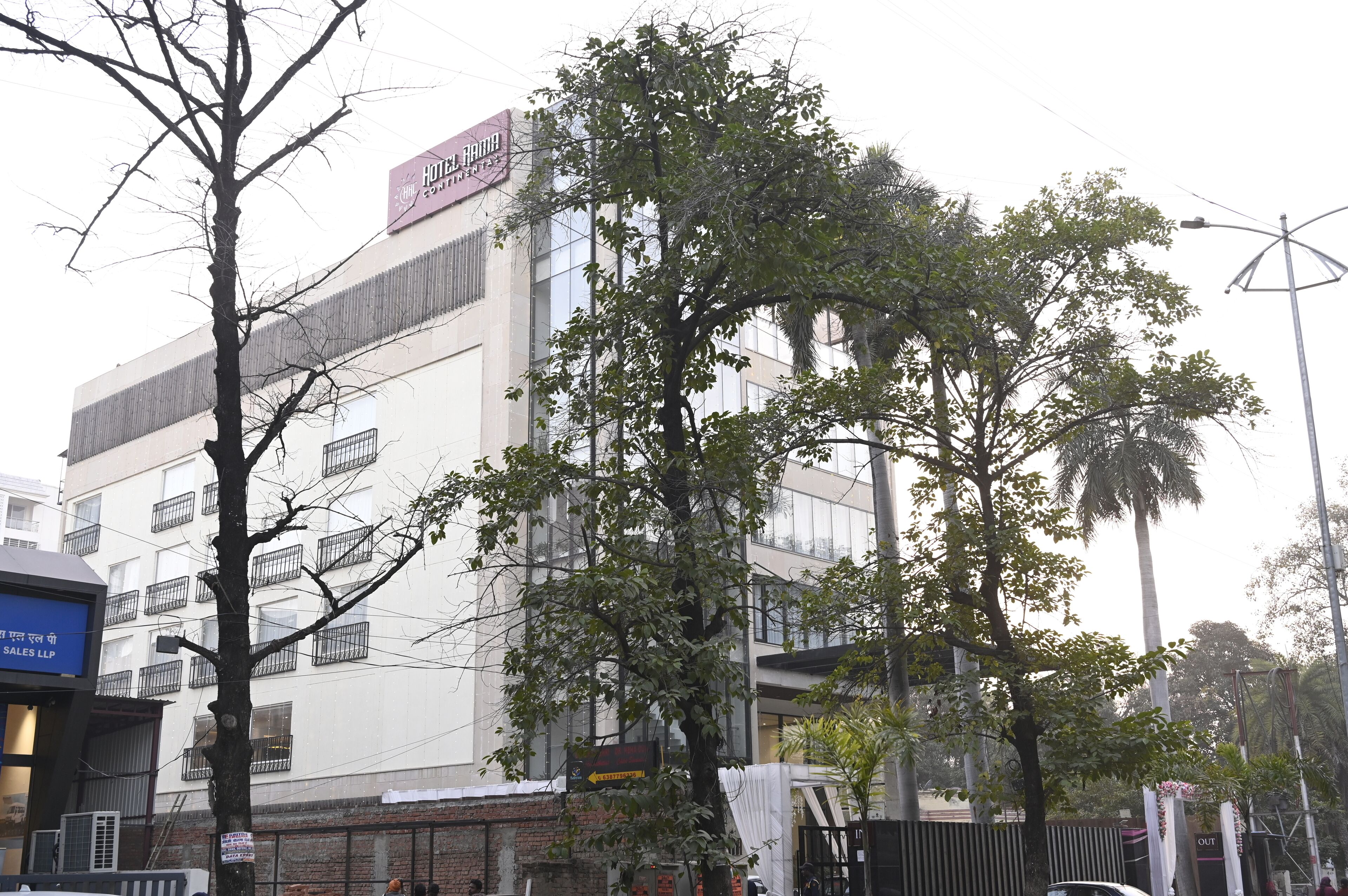 A hotel with a modern facade, multiple floors, and a prominent sign.