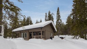 Een chalet omringd door sneeuw, onder een heldere hemel.