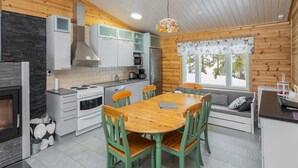 Een moderne keuken met een eethoek, houten wanden en een groot raam.