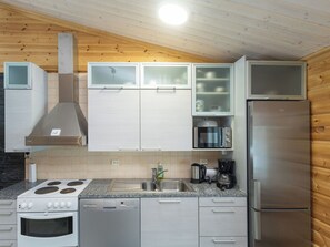A modern kitchen with a stainless steel refrigerator, built-in microwave, and a stove.