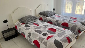 A double bed with a white headboard and a patterned bedspread. - Très bel Appartement de 71 m², vue sur mer 250 m de la Plage ,du Centre-ville (L'Île-Rousse)