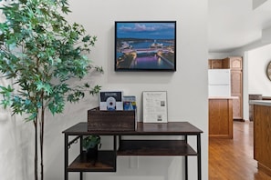 A room with a wooden table displaying a framed welcome sign, a framed welcome sign, and a brochure. - Loft above the Villager Pub with Round Lake marina sunsets — walk Bridge St + East Park. (Charlevoix)