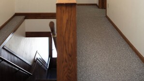 A room with a wooden staircase, a white ceiling light, and two wooden doors. - Loft above the Villager Pub with Round Lake marina sunsets — walk Bridge St + East Park. (Charlevoix)