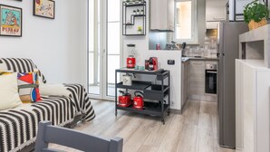 A modern apartment with a living room, kitchen, and dining area. There is a sofa, a dining table, and a kitchen counter. - Il Rifugio del Viaggiatore by Wonderful Italy (Turin)