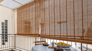 A balcony with a table set for two, a bowl of fruit, and a coffee pot. - Syracuse Comfy Retreat by Wonderful Italy (Syracuse)