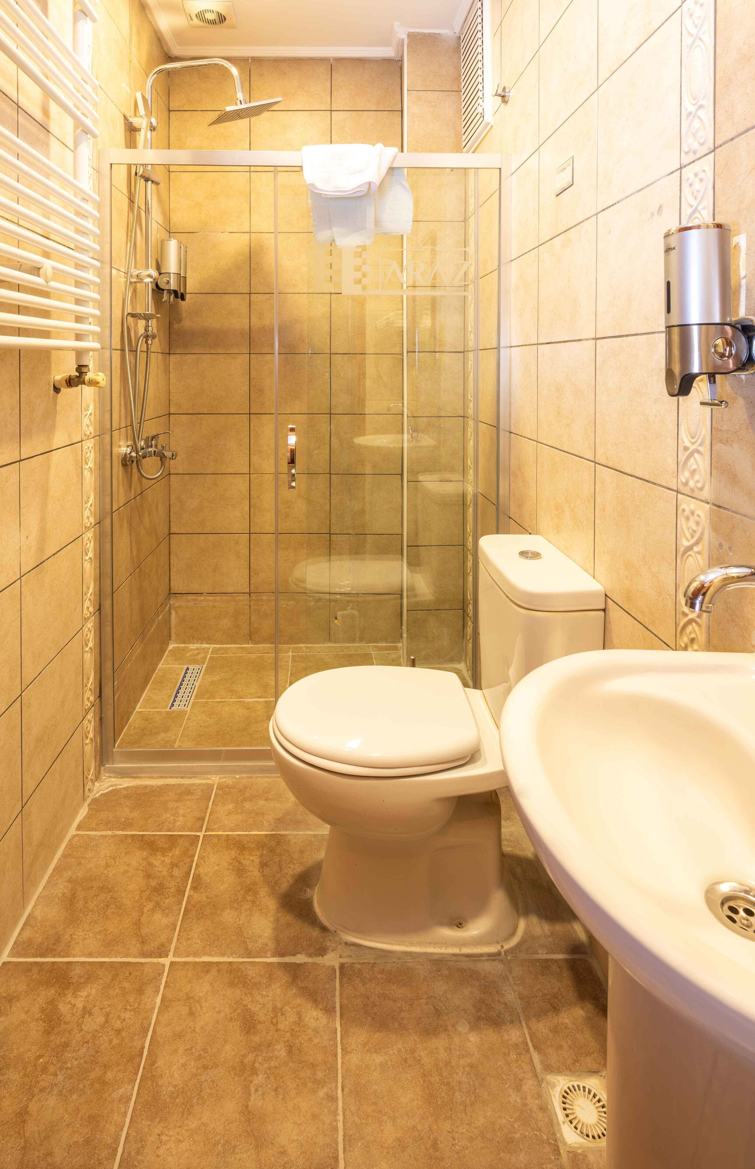 Un baño con ducha de mampara, inodoro y lavabo.