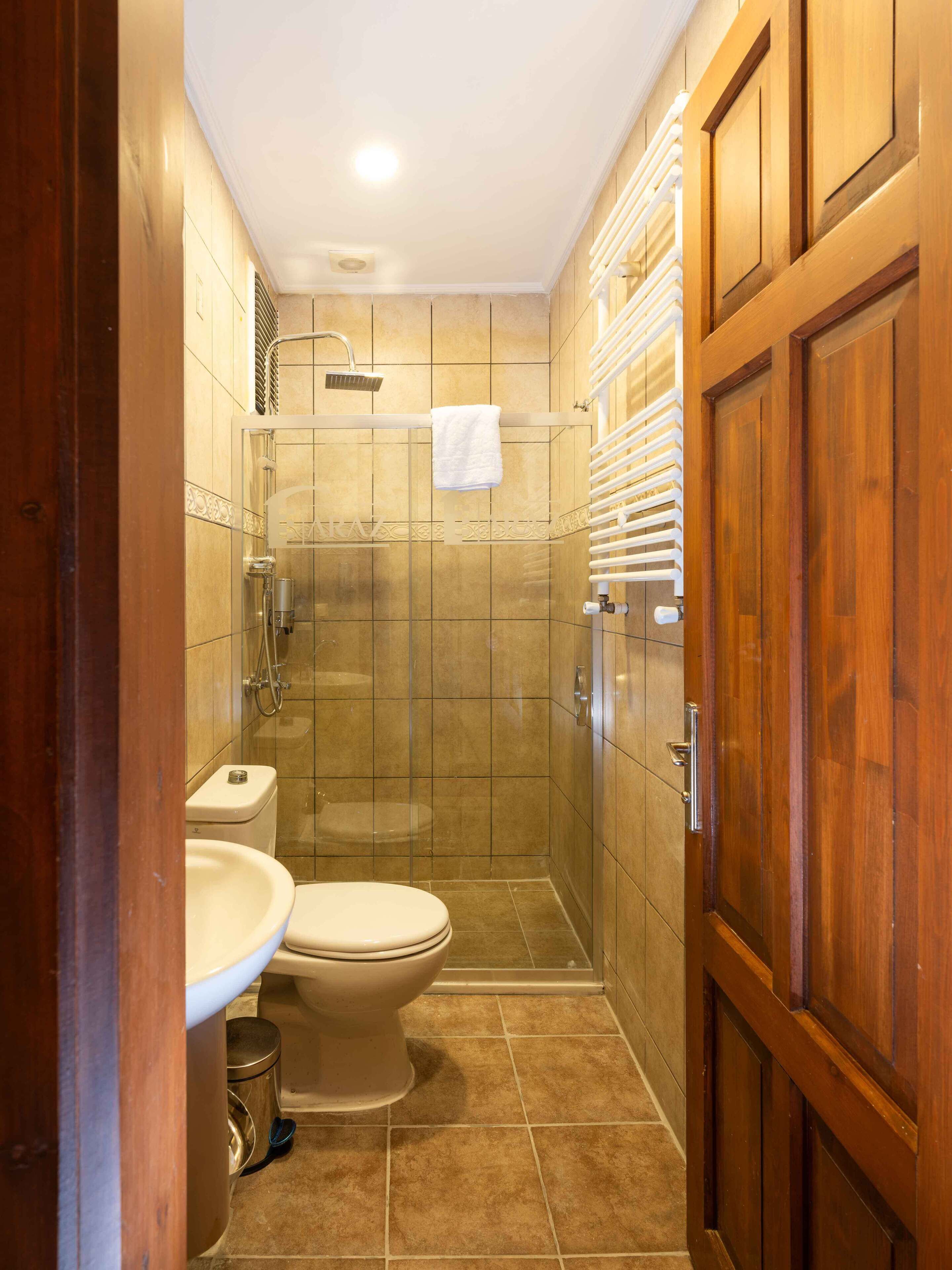 A bathroom with a toilet, sink, and shower.