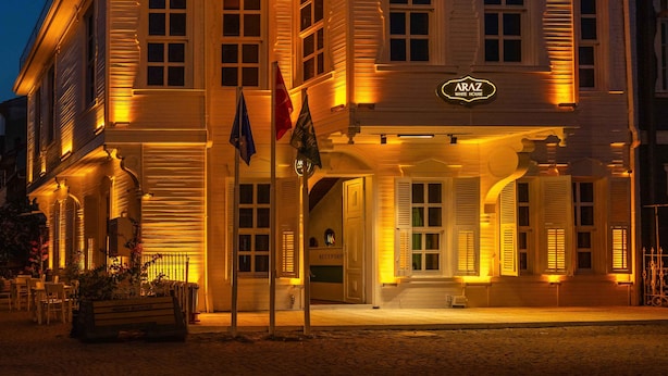 A historic building with a prominent entrance, a reception area, and flags displayed outside. - Araz White House (Mudanya)