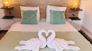 Een hotelkamer met een bed, kussens en een handdoekdecoratie in de vorm van zwanen.
