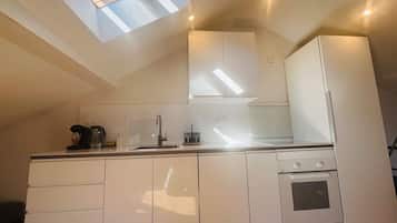 Køleskab, kaffe-/temaskine, køkkentøj/tallerkener/redskaber, spisebord