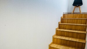 Eine Holztreppe mit einem schwarzen Stuhl auf der obersten Plattform.