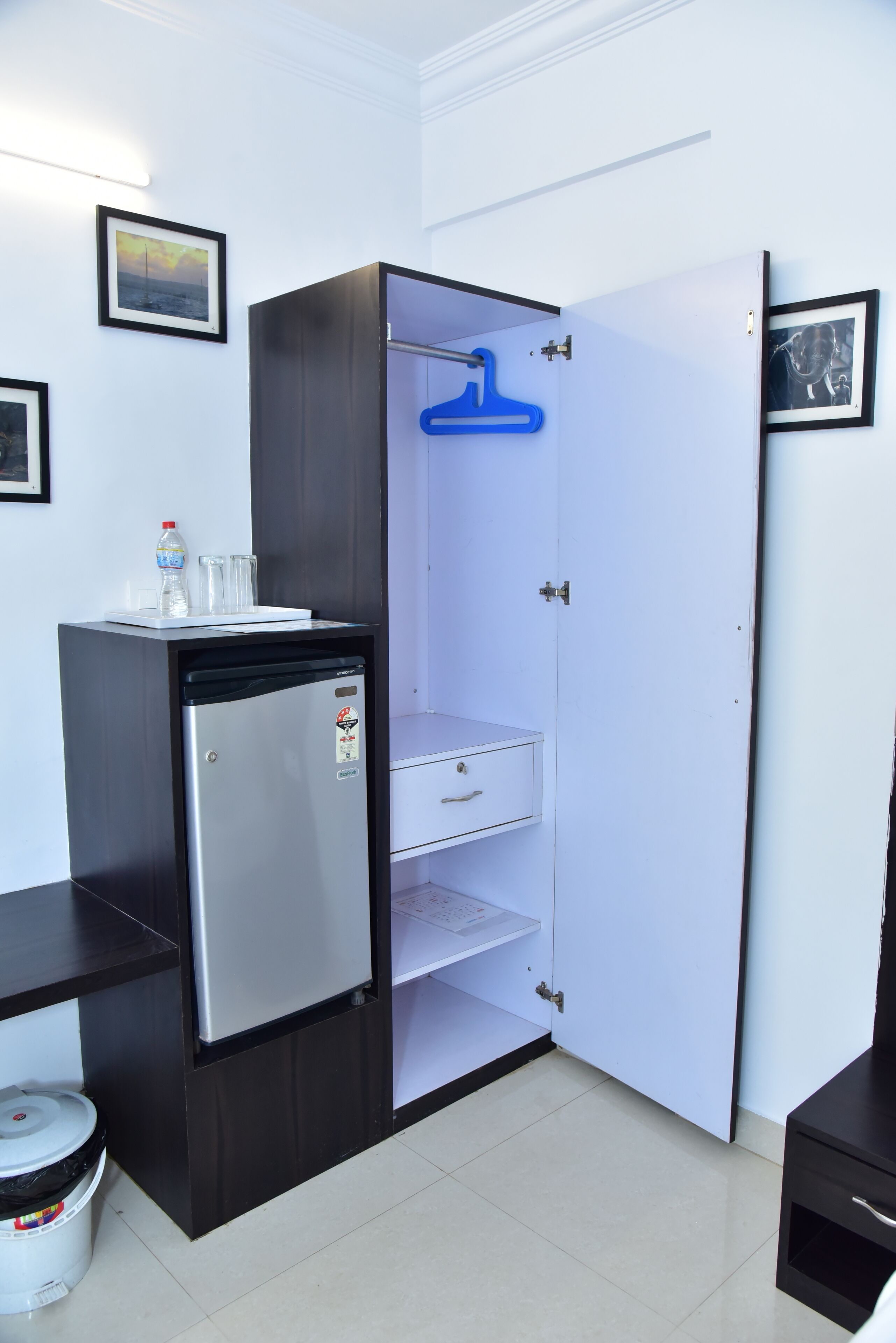 A compact room with a built-in refrigerator, a small sink, and a storage cabinet.