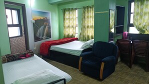 A room with two beds, a desk, and a chair. - Our Villa Guest House (Shillong)