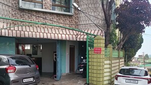 A building with a tiled facade, a green awning, and a sign indicating 'Our Villa Guest House'. - Our Villa Guest House (Shillong)