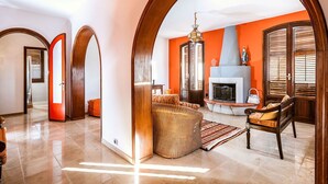 Un salon spacieux avec une cheminée, un canapé et une table basse.
