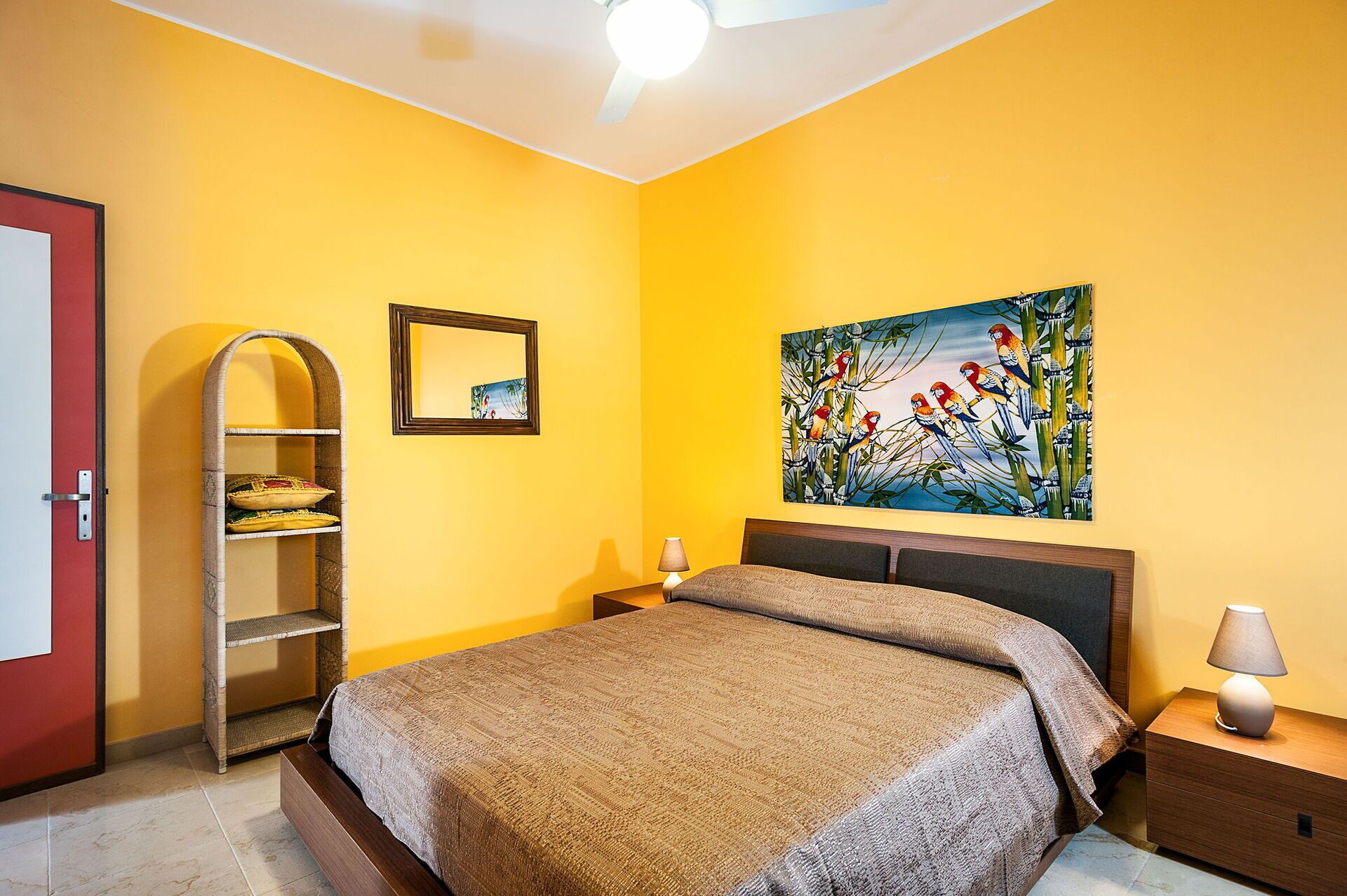 A bedroom with a bed, a nightstand, a lamp, a shelf, and a painting on the wall.