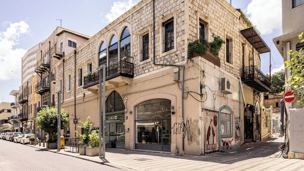 Un edificio histórico con ventanas arqueadas y una tienda en la planta baja.