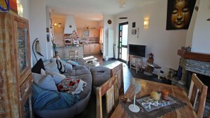 A living room with a grey sofa, wooden coffee table, and a TV.