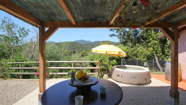 A covered outdoor seating area with a table, chairs, a hot tub, and a view of the surrounding landscape. - Beautiful private villa for 3 guests with A/C, hot tub, TV, veranda, pets allowed and panoramic ... (Castiglione Della Pescaia)