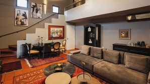 Un salon moderne avec un canapé gris, une table basse et un escalier menant à un niveau supérieur.