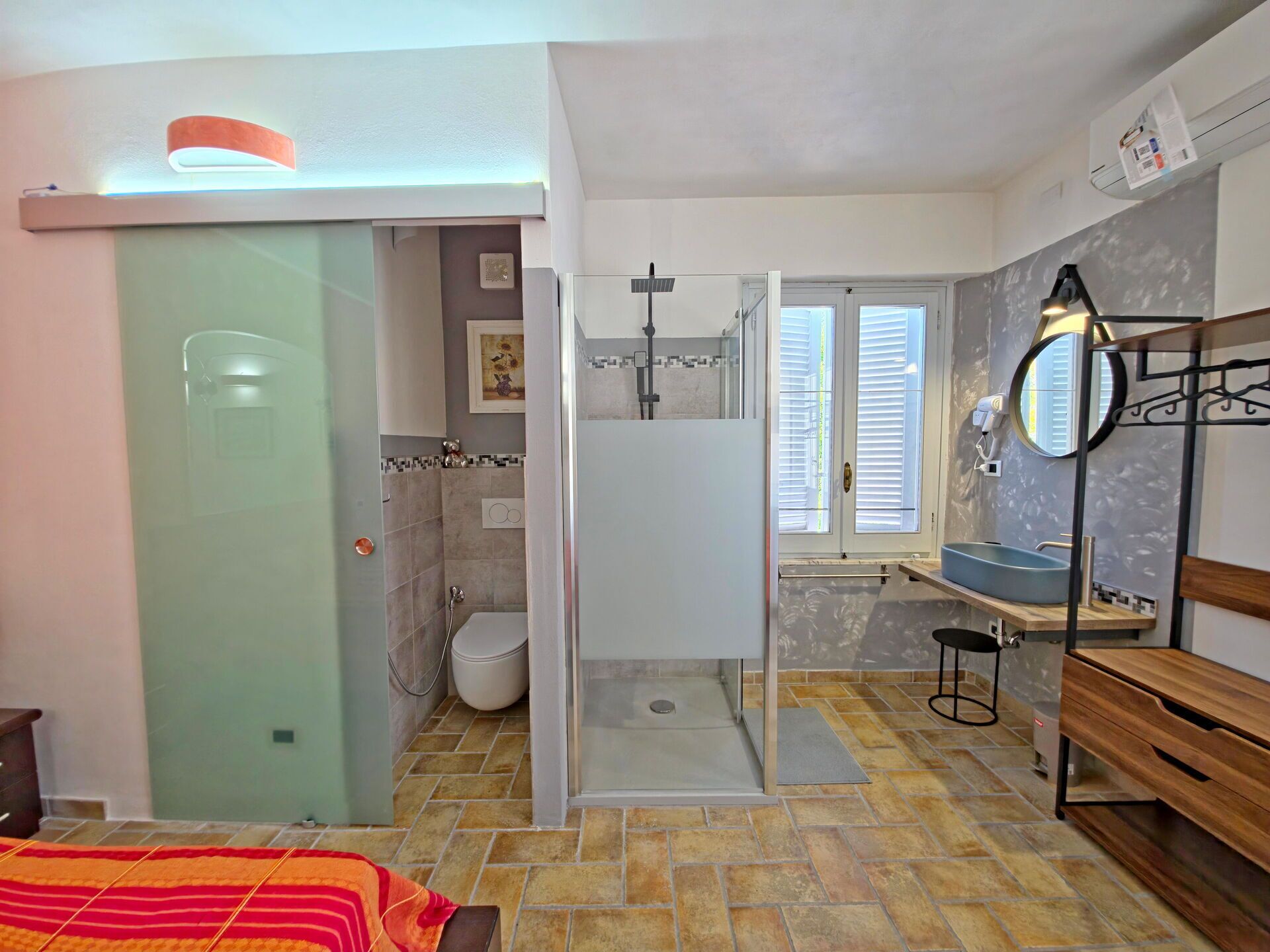 Une salle de bain avec douche, toilettes et lavabo.