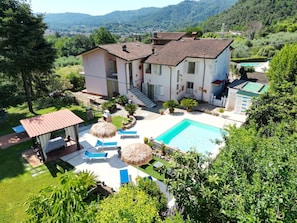 A two-story house with a swimming pool, outdoor seating, and a garden. - Villa with A/C, WIFI, private pool, TV, veranda, pets allowed, panoramic view, close to Viareggio (Camaiore)