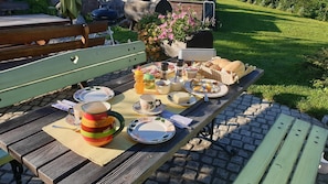 Enjoy a casual meal outdoors with a picnic table set amidst a lush green area.