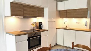 A compact kitchen with white cabinets, a wooden countertop, a coffee maker, and a sink. - CAP D'agde, Agréable 2 Pièces 42m2, Loggia, 4 Voyageurs, 300m Plage du Môle (Agde)
