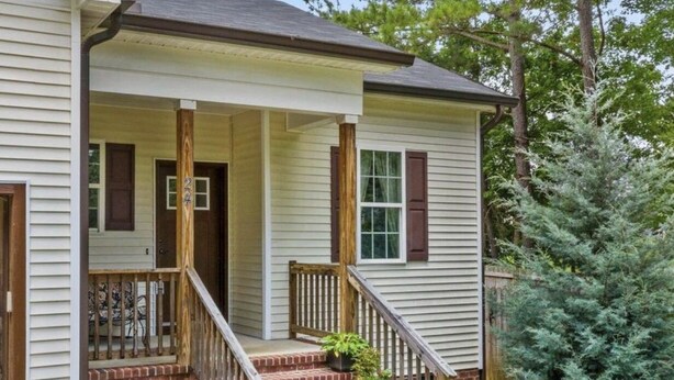 A two-story house with a front porch, brick steps, and a small front yard with a tree. - HO HO HO! Holiday Discount (Franklinton)