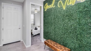 Een kamer met een groene wand, een witte deur en een bank.