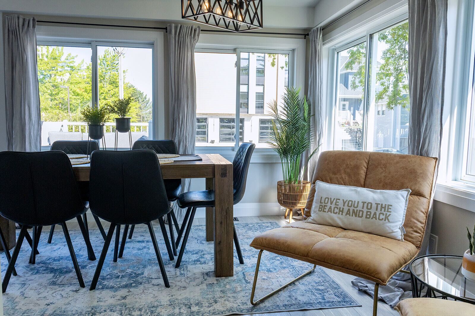 Una sala de estar moderna con comedor, ventanas amplias y vistas a la ciudad.