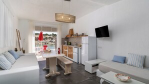 Een compact verblijf met kitchenette, een eethoek en een zithoek met uitzicht op het groen.