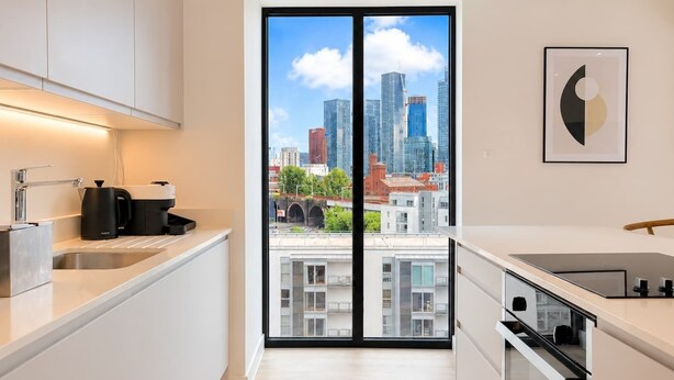 Une cuisine moderne avec vue sur la ville, une machine à café et un évier.