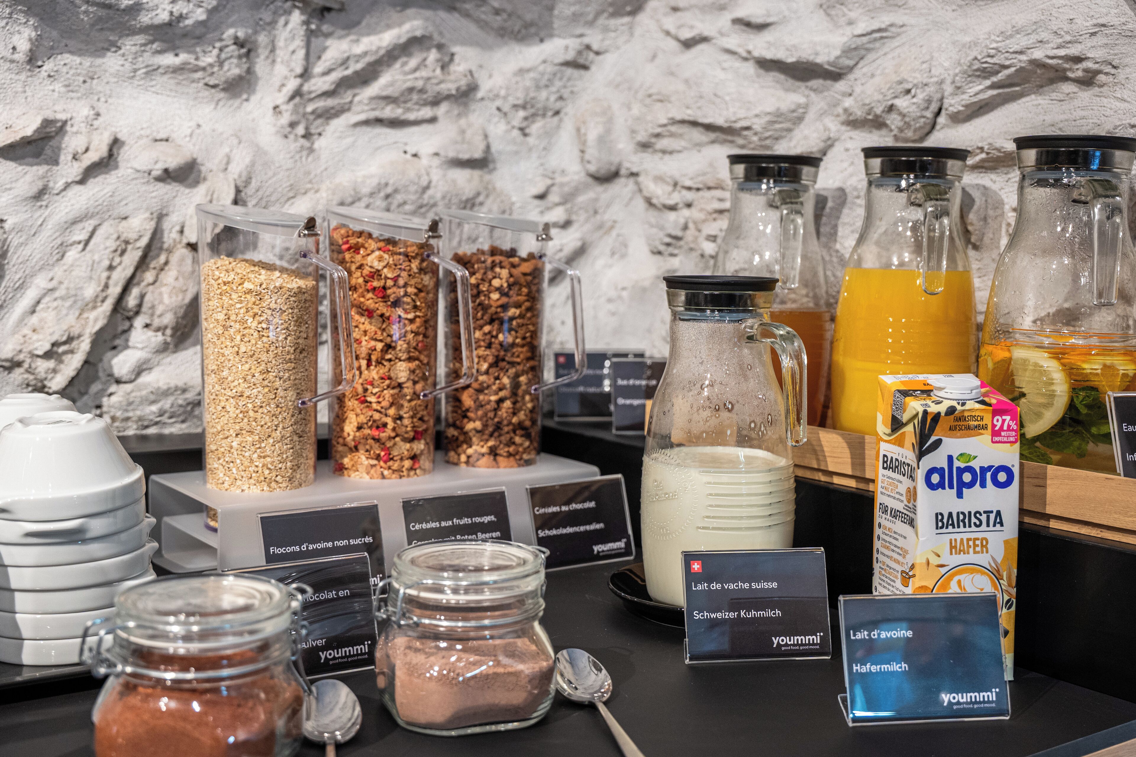 Buffet de l'esmorzar amb diferents aliments i begudes, com ara cereals, granola i llet.