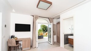 A modern bedroom with a desk, chair, and a TV mounted on the wall. - La Minucciola (Anacapri)