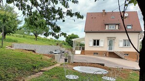 A house with a patio area featuring outdoor furniture and a small garden.