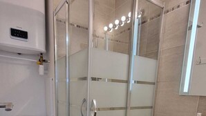 A modern bathroom with a glass-enclosed shower, a toilet, a sink, and a mirror. - PLEASANT LITTLE STUDIO IN SAINT-RAPHAËL  (Saint-Raphaël)