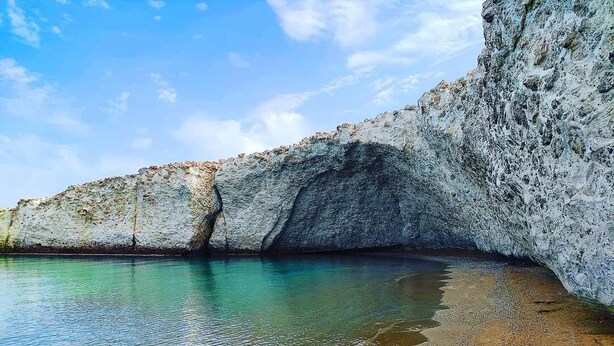 A coastal scene with a rocky cliff and calm water. - FANI DREAM SUITE By Vilos Suites (Milos)