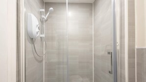 A modern shower with a handheld showerhead and a wall-mounted control panel. - Host & Stay | Clifton Studio 1 (Darlington)