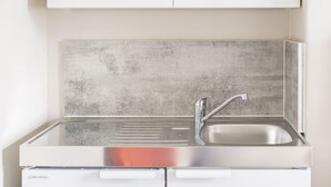 A modern kitchen with a stainless steel sink, a single faucet, and a cabinet above. - Host & Stay | Clifton Studio 4 (Darlington)